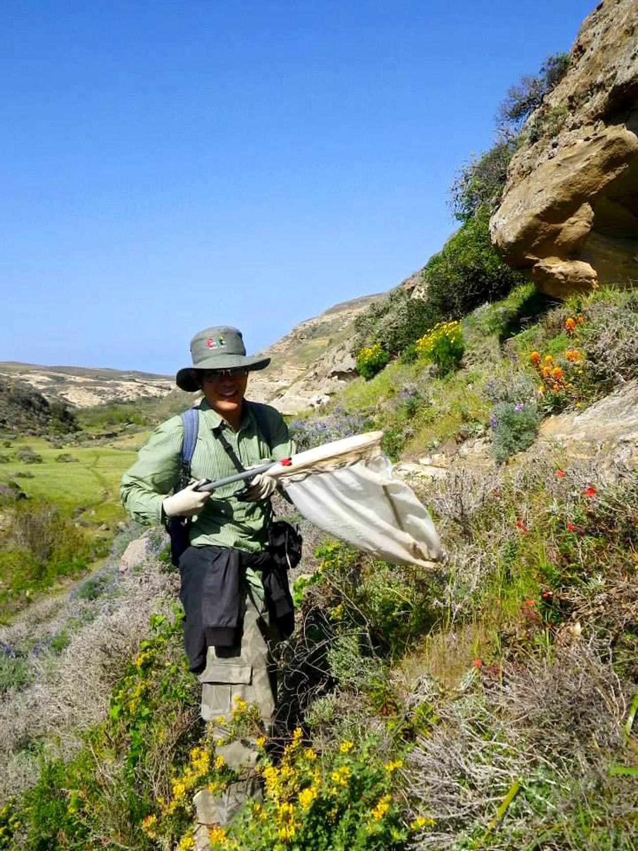 Hung holding a net in the scrub habitat