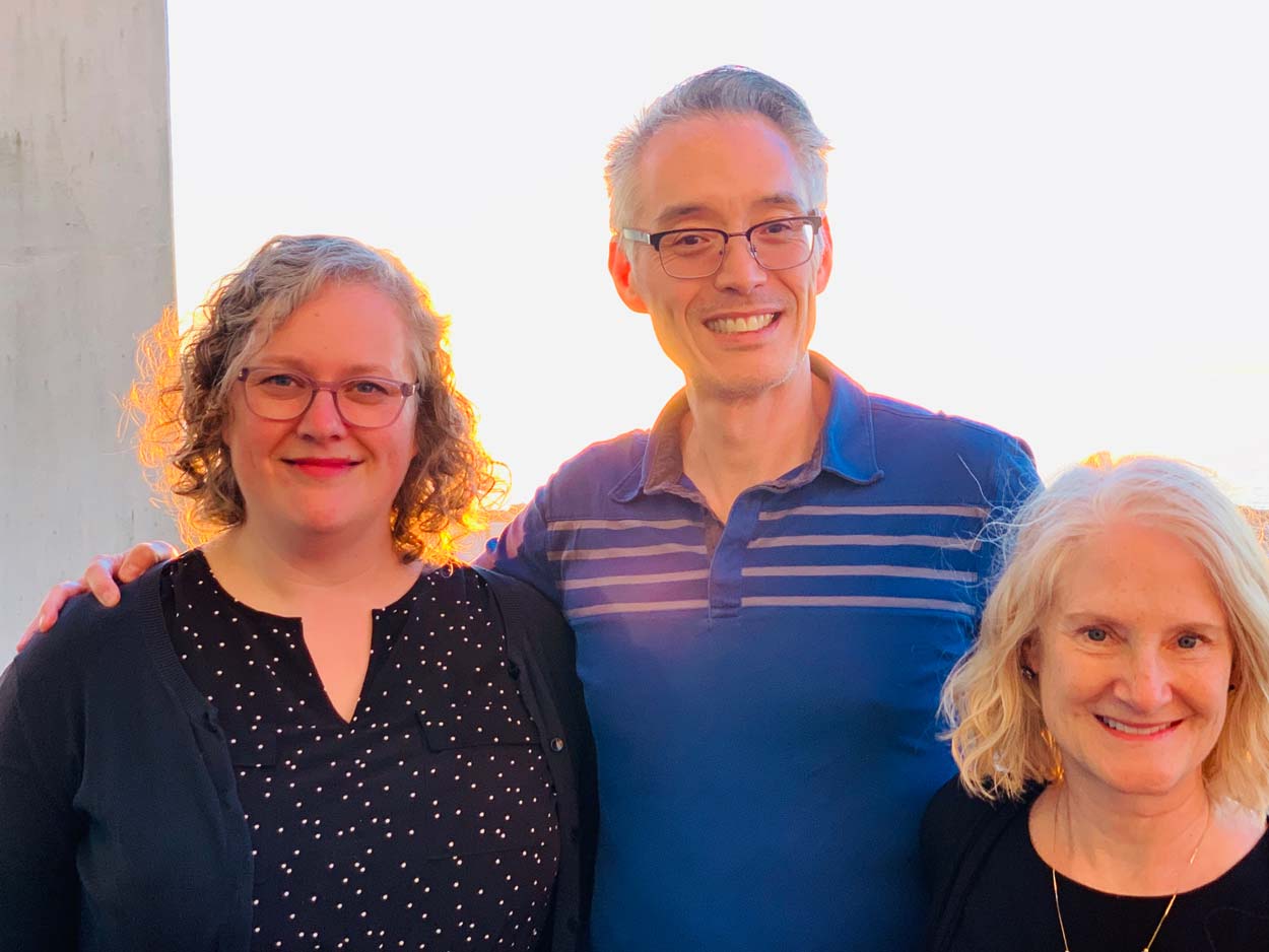 Images of 2 women and 1 man smiling at camera with sunset behind them