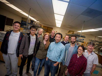 lab members standing in a group in the lab to have their photo taken